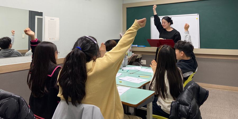 수업 중 손을 든 아이들과 선생님